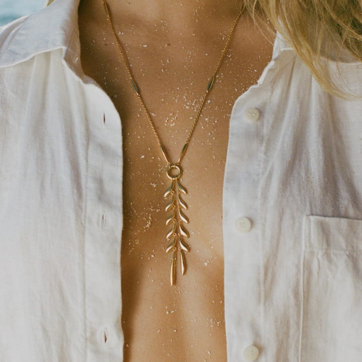 Image of model wearing the Fishbone Necklace wearing a linen blouse.