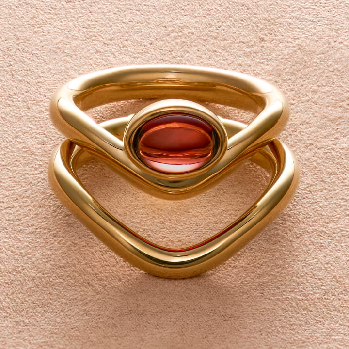 Still life image of the Harvest Ring in gold vermeil and garnet with the Harvest Stacking Ring. 